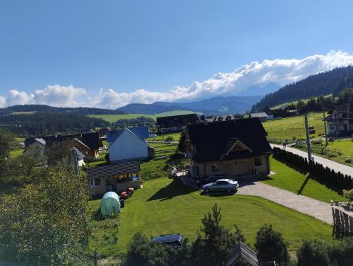 una vista aerea di un villaggio con montagne sullo sfondo di Agroturystyka nad brzegiem a Kacwin
