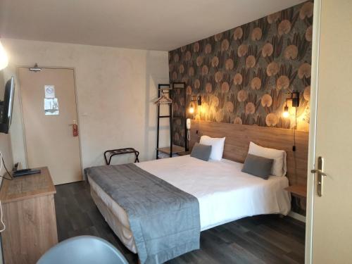 1 dormitorio con 1 cama grande y cabecero de madera en Hotel Au Sans Souci, en Chinon