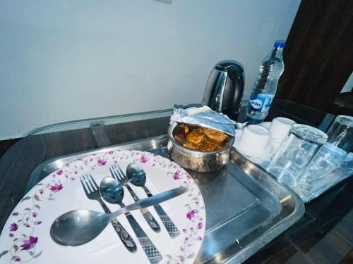un lavandino con un piatto e utensili sopra di Hotel Badal Inn - Safdarjung Enclave a Nuova Delhi