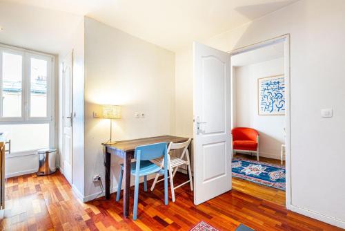 a small apartment with a table and chairs in a room at GuestReady - Vibrant landscape in the 19th arr. in Paris
