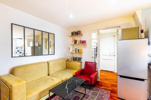 a living room with a couch and a refrigerator at GuestReady - Vibrant landscape in the 19th arr. in Paris