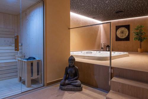 eine Statue in einem Badezimmer mit Badewanne in der Unterkunft Luxury Seaview Resort Apartment in Manilva