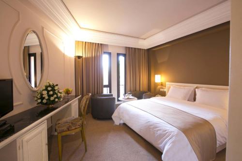 Habitación de hotel con cama grande y espejo en Nassim Hôtel en Marrakech