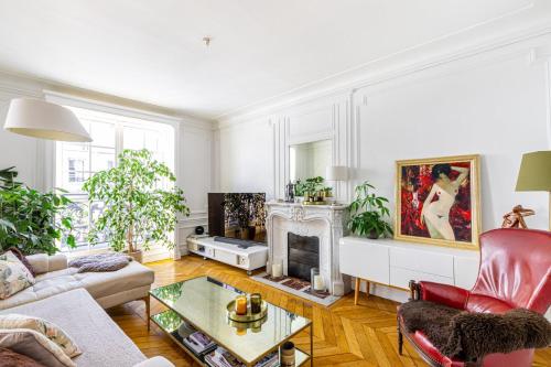 - un salon avec une cheminée et un fauteuil rouge dans l'établissement GuestReady - Grand apt lumineux à Montmartre, à Paris