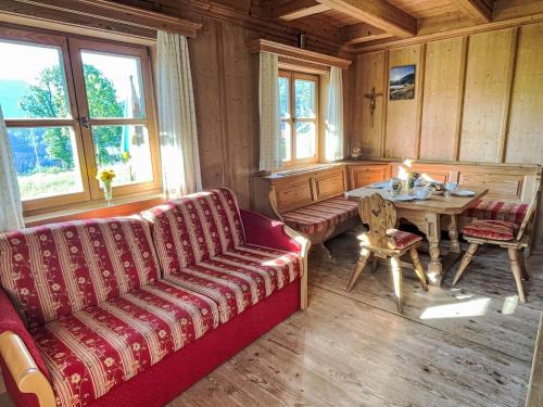 a living room with a red couch and a table at Holiday Home Marianne by Interhome in Reit im Winkl