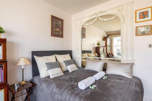 Schlafzimmer mit einem Bett und einem großen Spiegel in der Unterkunft GuestReady - Flor de solstício de verão no 12º arr. in Paris