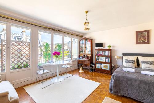 ein Wohnzimmer mit einem Sofa und einem Tisch in der Unterkunft GuestReady - Flor de solstício de verão no 12º arr. in Paris