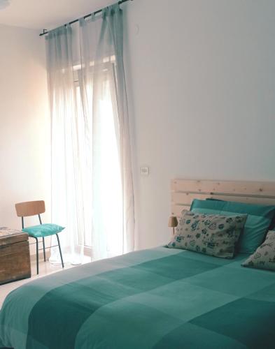 a bedroom with a green bed and a window at B&B Casa Giardino Ferrazzano in Ferrazzano
