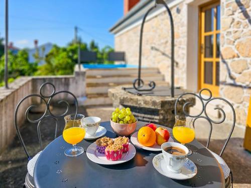 una mesa con platos de comida y vasos de jugo de naranja en Apartment Mia by Interhome, en Dobrinj