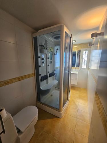 een badkamer met een douche, een wastafel en een toilet bij Chalet adosado in Cullera