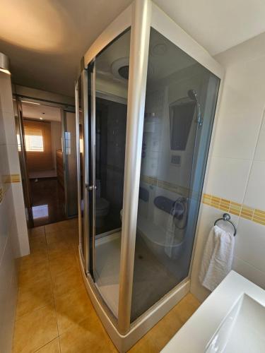 a shower with a glass door in a bathroom at Chalet adosado en la playa in Cullera
