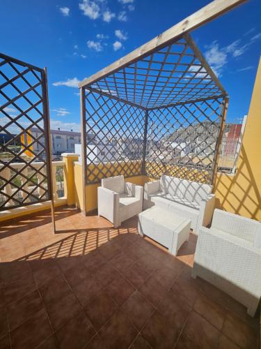 a balcony with white furniture on a roof at Chalet adosado en la playa in Cullera