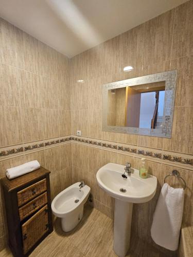 a bathroom with a sink and a toilet and a mirror at Chalet adosado en la playa in Cullera