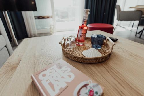 una mesa con una botella de alcohol y vasos. en Fewo Lachmoewe Haus Mellum, en Hooksiel
