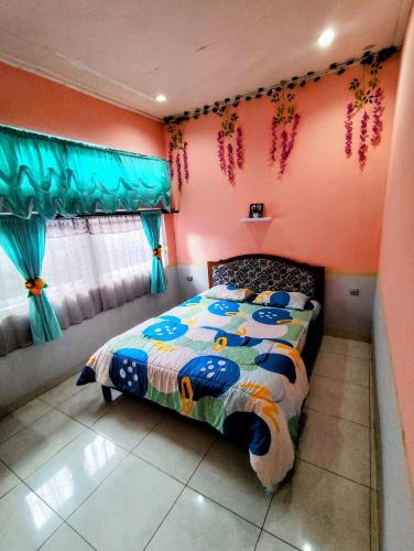 a bedroom with a bed in a room with pink walls at D-Rima Homestay Ruteng in Ruteng