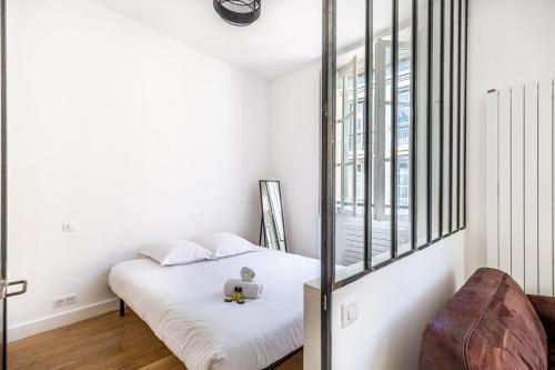 une chambre blanche avec un lit et une fenêtre dans l'établissement GuestReady - A bright minimalism in the centre, à Bordeaux