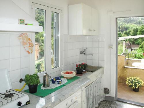 Una cocina blanca con fregadero y ventana. en Apartment Casa Petrella - DOL137 by Interhome, en Dolcedo