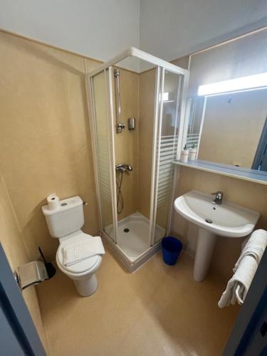 La salle de bains est pourvue de toilettes et d'un lavabo. dans l'établissement Hôtel Le Juliano, à Carbon-Blanc