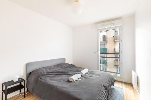 - une chambre avec un lit et 2 serviettes en papier dans l'établissement GuestReady - Cosy and Calm in Suresnes, à Suresnes