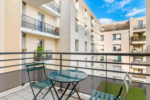 a balcony with a table and chairs and a building at GuestReady - Cosy and Calm in Suresnes in Suresnes