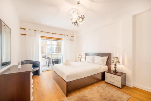 シャルネカにあるGuestReady - Caparica Beach Lover's Dreamのベッドと窓のある白い寝室