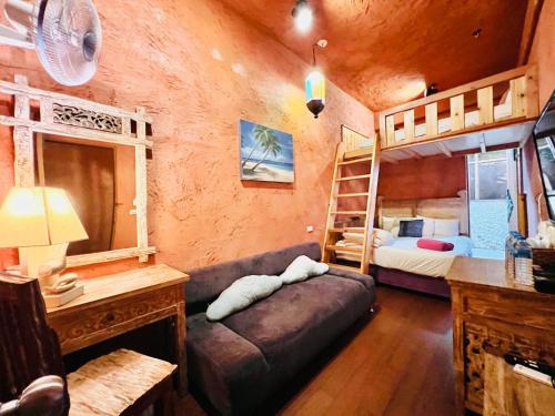 南湾にあるKenting Afei Surf Hostel Nanwanのベッドルーム1室(二段ベッド2台、ソファ付)