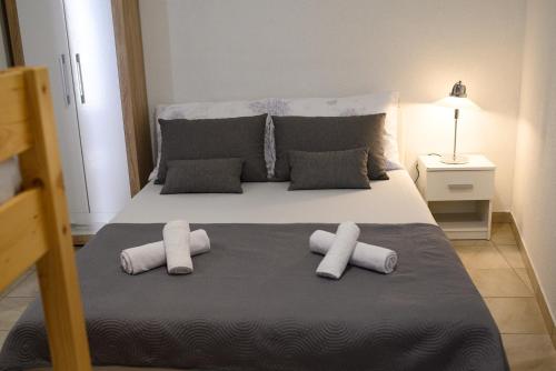 a bedroom with a bed with three pillows on it at Apartments Coric in Trogir