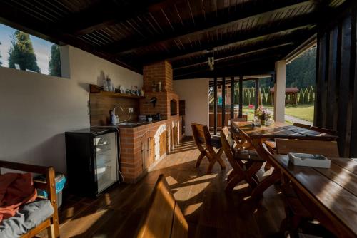 a kitchen and dining room with a table and a fireplace at Natúr Vendégház in Miercurea-Ciuc