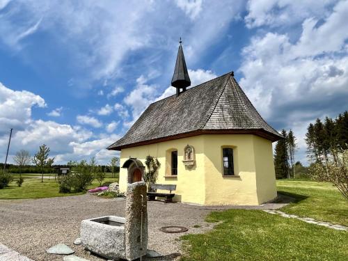 a small church with a steeple on top of it at Apartment Hochfirst-2 by Interhome in Dittishausen