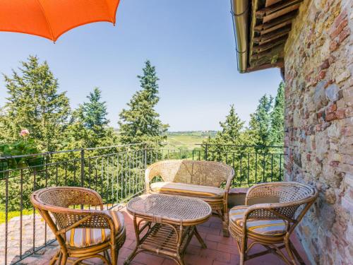 a patio with chairs and a table and an umbrella at Apartment Casa Renai a San Gimignano-5 by Interhome in San Gimignano