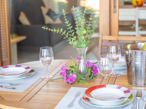 波爾圖波佐的住宿－Apartment Il Fjordo bilo - PPZ160 by Interhome，一张桌子,上面放有盘子和玻璃杯,还有紫色的鲜花