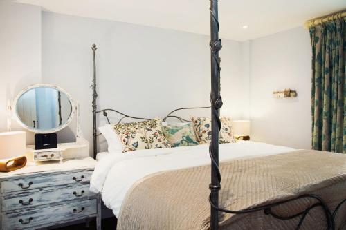 sypialnia z łóżkiem z lustrem i komodą w obiekcie The Burrow at Burrow Wood Farm w mieście Ottery Saint Mary