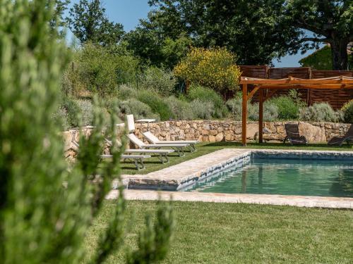 a swimming pool in a yard with a wooden pergola at Holiday Home Montecavallo by Interhome in Poggio Murella