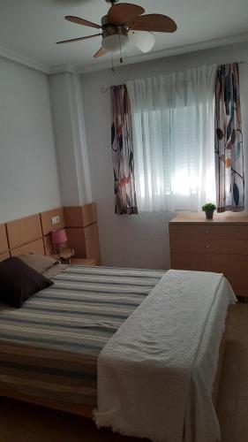 ein Schlafzimmer mit einem Bett und einem Deckenventilator in der Unterkunft Apartamento Magic World Oropesa in Oropesa del Mar