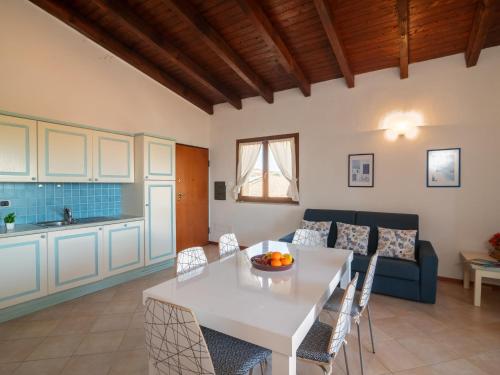 cocina y sala de estar con mesa blanca y sillas en Apartment I Mirti di Porto Pozzo - PPZ122 by Interhome, en Porto Pozzo