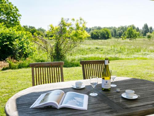 バダチョニトマイにあるHoliday Home Emi - BAC110 by Interhomeの本とワインのボトルを用意したテーブル
