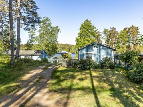 an empty road in front of a blue house at Chalet Sandsjöfors by Interhome in Sandsjöfors