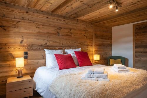 - une chambre avec un grand lit et des murs en bois dans l'établissement Apartment Duplex La Renardière, aux Gets