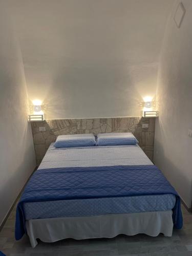 a bed in a small room with two lights at Acqua Marina casa vacanza in Vieste