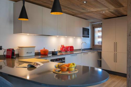 une cuisine avec une table avec un bol de fruits dessus dans l'établissement Apartment Duplex La Renardière, aux Gets