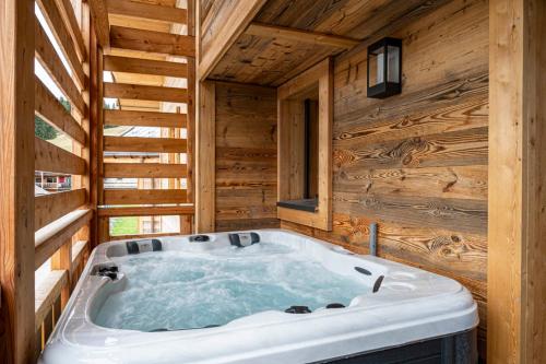 une baignoire jacuzzi dans une cabane en rondins dans l'établissement Apartment Duplex La Renardière, aux Gets