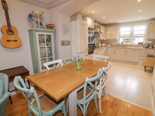 a kitchen and dining room with a wooden table and chairs at 3 Coastguard Station in Rathmullan