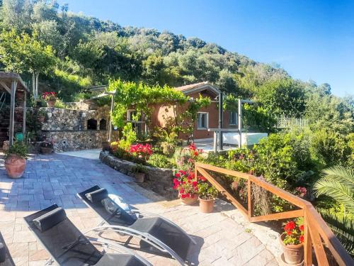 une terrasse avec des chaises et des fleurs et une maison dans l'établissement Holiday Home La Tordara by Interhome, à Porto Santo Stefano