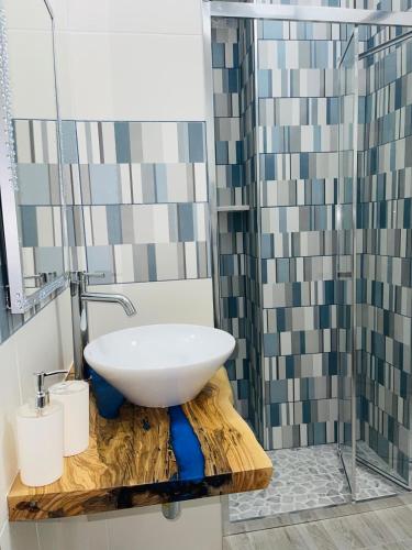 a bathroom with a white sink on a wooden counter at Acqua Marina casa vacanza in Vieste