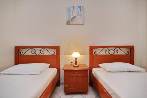 two beds in a room with a lamp on a table at Efi's studios in Paralion astros