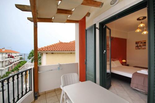 a room with a balcony with a bed and a bedroom at Efi's studios in Paralion astros