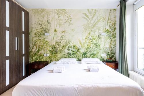 - une chambre avec un grand lit et du papier peint floral dans l'établissement GuestReady - Bel Apt. au cœur de Paris, à Paris