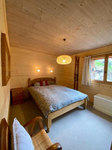 une chambre avec un lit dans une cabane en rondins dans l'établissement Appartement cosy, spacieux & moderne - 95m2, à Lanslebourg-Mont-Cenis