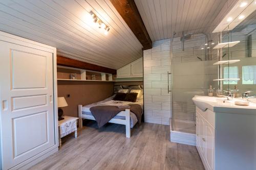 Un dormitorio con una cama y un baño con lavabo. en Chalet Le Grand Nant, en La Giettaz