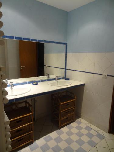 a bathroom with a sink and a large mirror at La Petite Vignolle in Saint-Amand-de-Coly